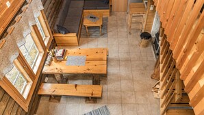 L’intérieur d’un chalet confortable, avec un canapé, des tables en bois et un chat.