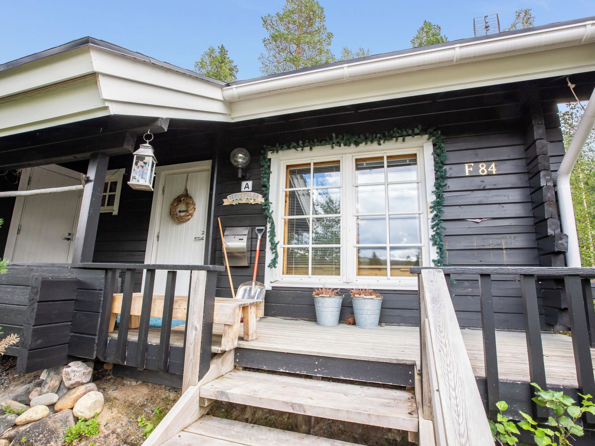 Een houten huis met een veranda, een deur en een raam.