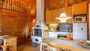 Ein gemütliches Holzhaus-Interieur mit Essbereich, Küche und einer finnischen Sauna.