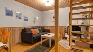 A cozy living room with a wooden ceiling, a sofa, a coffee table, and a bookshelf. - Korpipalo (ent. yllästunnelma 2 b 7) by Interhome (Ylläsjärvi)