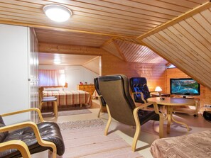 Une chambre mansardée agréable, avec un lit, un bureau, une chaise et un téléviseur.