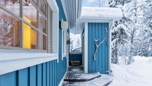 A snow-covered wooden deck leading to a house with blue siding and a white roof. - Korpipalo (ent. yllästunnelma 2 b 7) by Interhome (Ylläsjärvi)