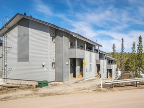 A multi-story building with a flat roof, a covered outdoor area, and a staircase leading to the entrance. - Rukatonttu d21 by Interhome (Kuusamo)