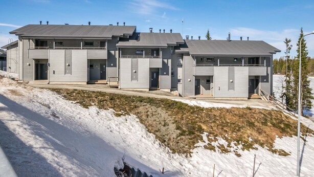 Un immeuble résidentiel moderne à plusieurs étages, doté d’un toit plat et d’une conception symétrique.