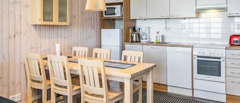A compact kitchen with white cabinets, a microwave, a coffee maker, and a Bosch oven.
