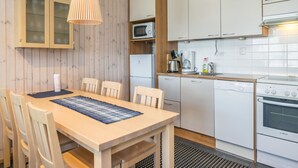 Une cuisine compacte dotée de meubles en bois, d’un four à micro-ondes, d’un lave-vaisselle Bosch et d’un four Bosch.