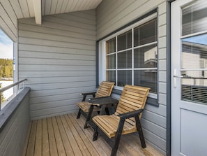 A covered porch with wooden flooring, two wooden chairs, a small table, and a window with blinds. - Rukatonttu d21 by Interhome (Kuusamo)