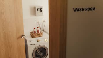 Máquina de lavar com painel de controle e cesto cheio de frascos de detergente.