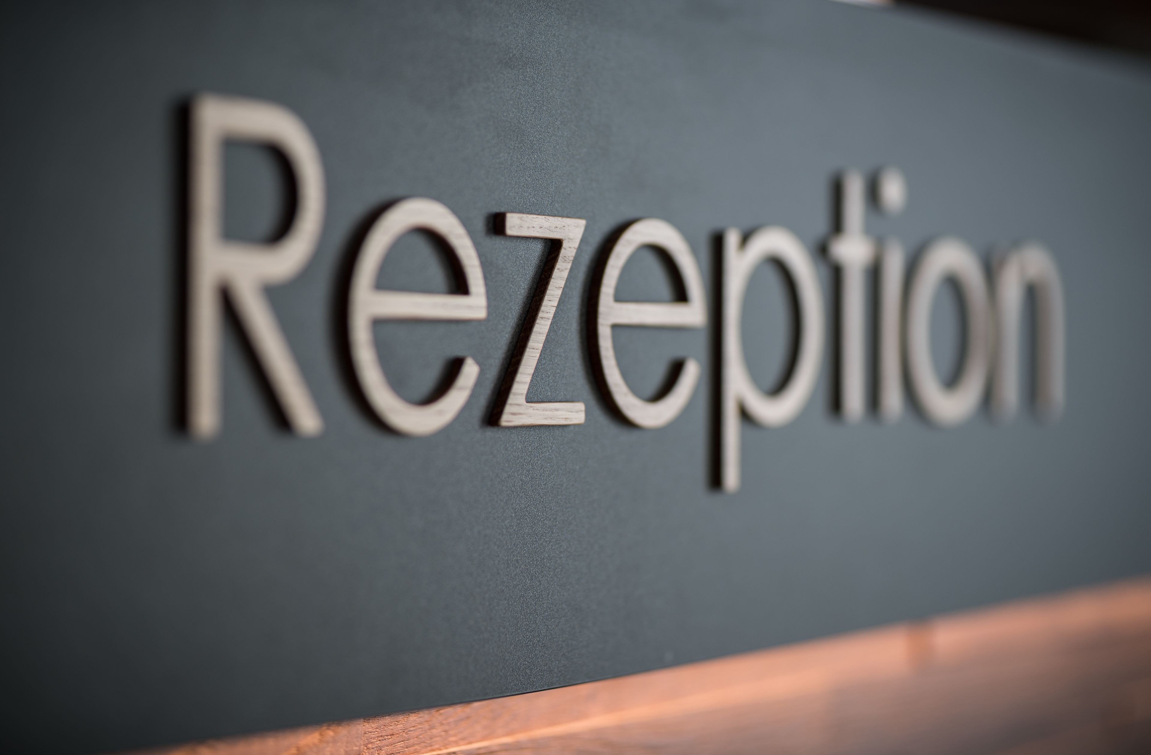 A sign with the word "Reception" in a serif font on a dark background.