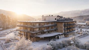 Un hôtel à plusieurs étages au design moderne, doté de balcons et d’un espace extérieur couvert.