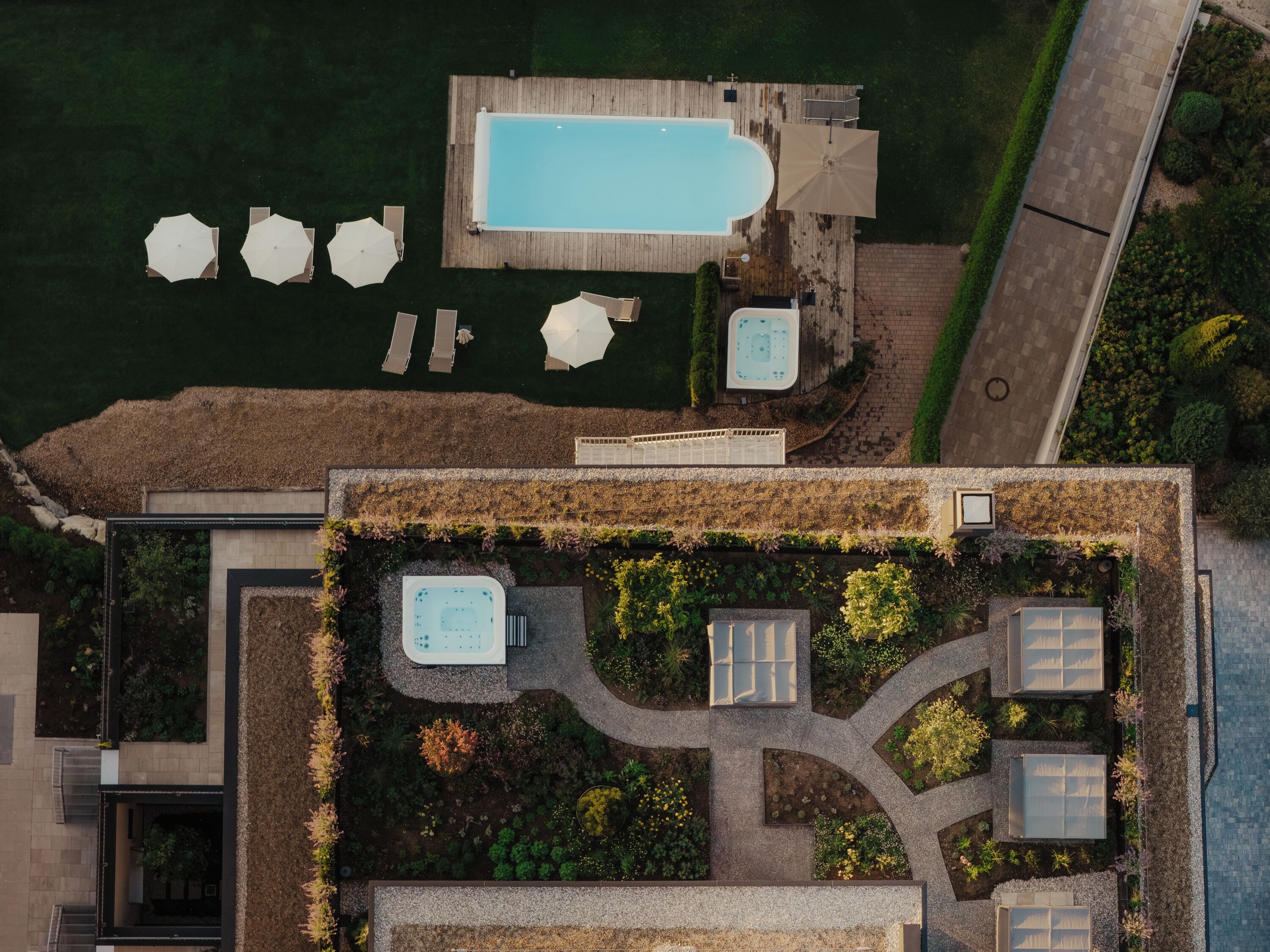 Vista aérea de una azotea con piscina, jacuzzis y mobiliario para exteriores.