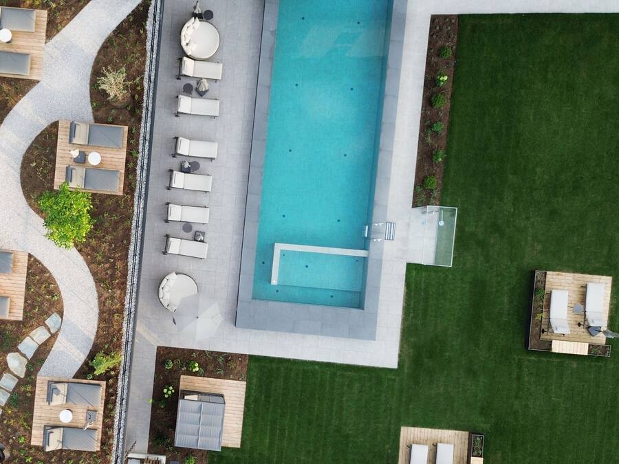 A rooftop pool area with multiple lounge chairs and a swimming pool.