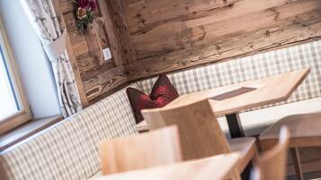 A wooden interior with a checkered bench and a table.