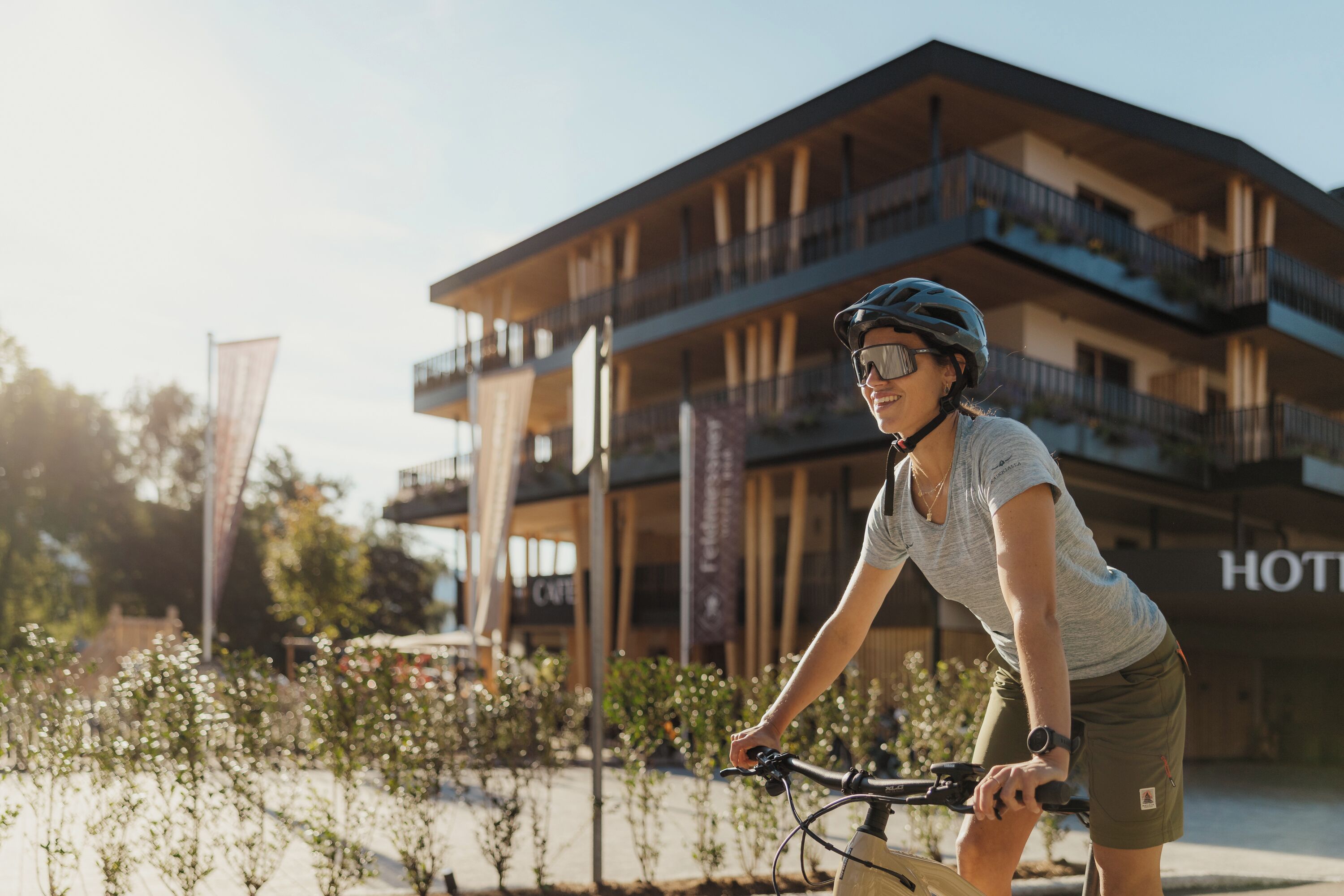 Una persona montando en bicicleta frente a un hotel con varios balcones y un letrero que dice "HOTEL".
