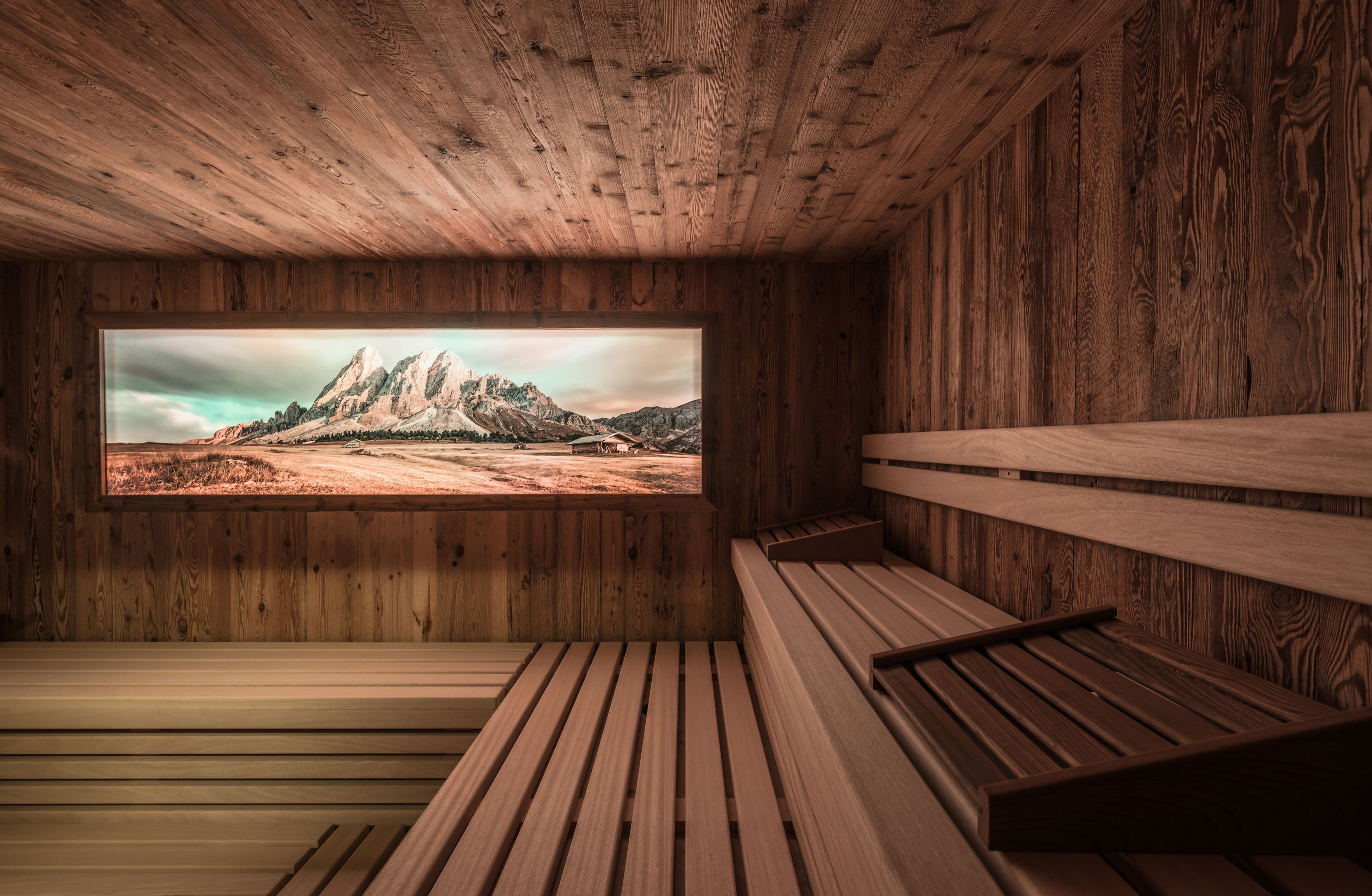 A wooden interior with a large window displaying a mountainous landscape.