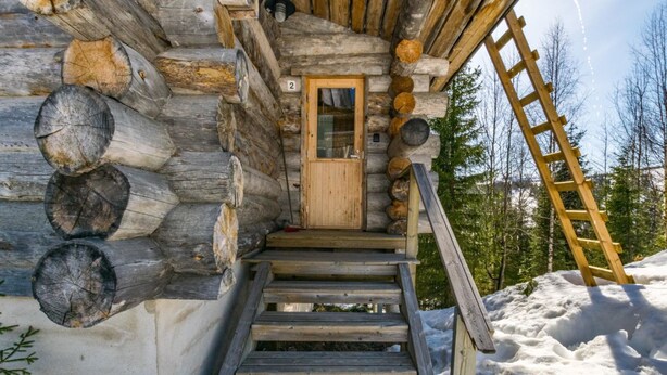 A log cabin with a wooden staircase leading to a door, surrounded by snow. - Rinnekieppi 2 by Interhome (Kuusamo)