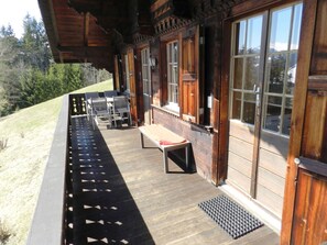 Un bâtiment en bois doté d’un porche abrité, de sièges en plein air et de grandes fenêtres.