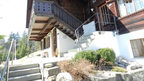 Un chalet in legno con una scala in pietra che conduce a un balcone.