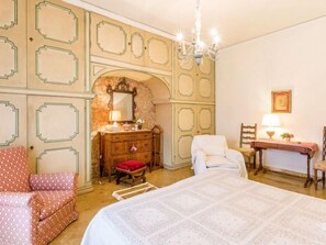 A bedroom with a large bed, a dresser, a chair, a desk, and a mirror. - La Torretta by Interhome (Florence)