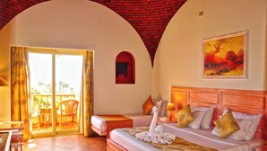 Una camera d'hotel con un letto, un balcone e un quadro appeso alla parete.