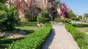 Un edificio a due piani con un vialetto fiorito che conduce all'ingresso.