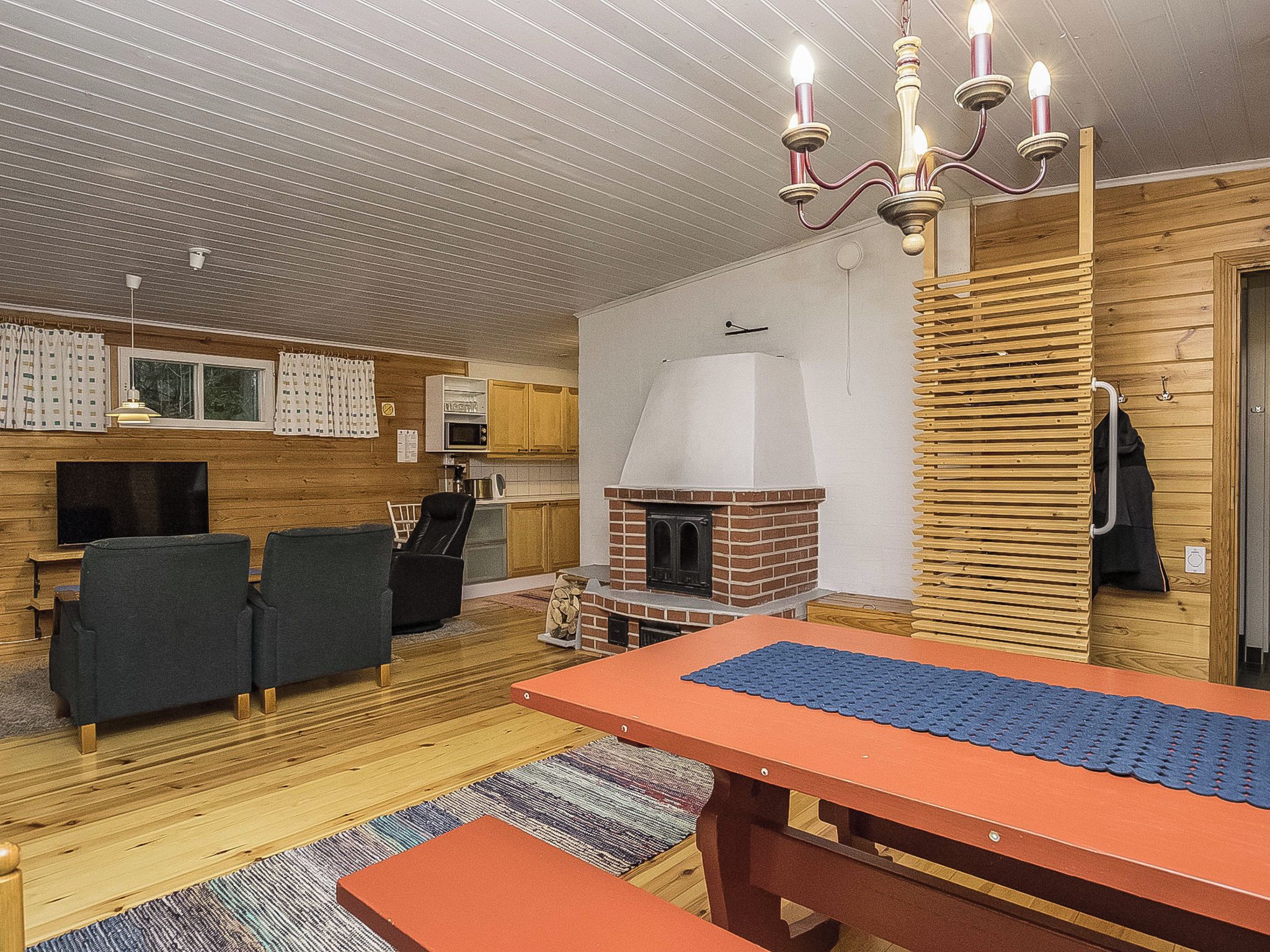 A cozy living area with a fireplace, a dining table, and a TV.