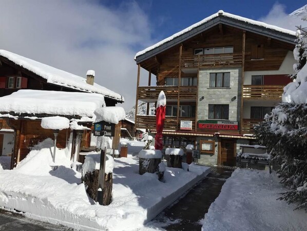 A wooden building with a sign for a restaurant and a private house.