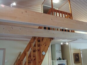 Un escalier en bois, doté d’une rampe, mène à un niveau supérieur.