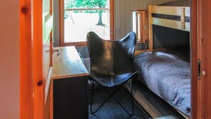Ein kleines Zimmer mit Etagenbett, Schreibtisch und Stuhl.
