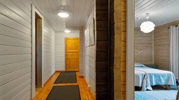 A narrow hallway with wooden walls and a wooden door at the end.