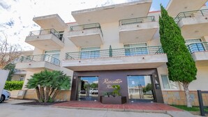 A multi-story building with balconies, a central entrance, and a sign reading "Rescator Resort". - Rescator Resort 115 - One Bedroom Resort, Sleeps 4 (Roses)