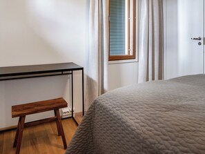 Une chambre à coucher avec un lit, un bureau et un banc.