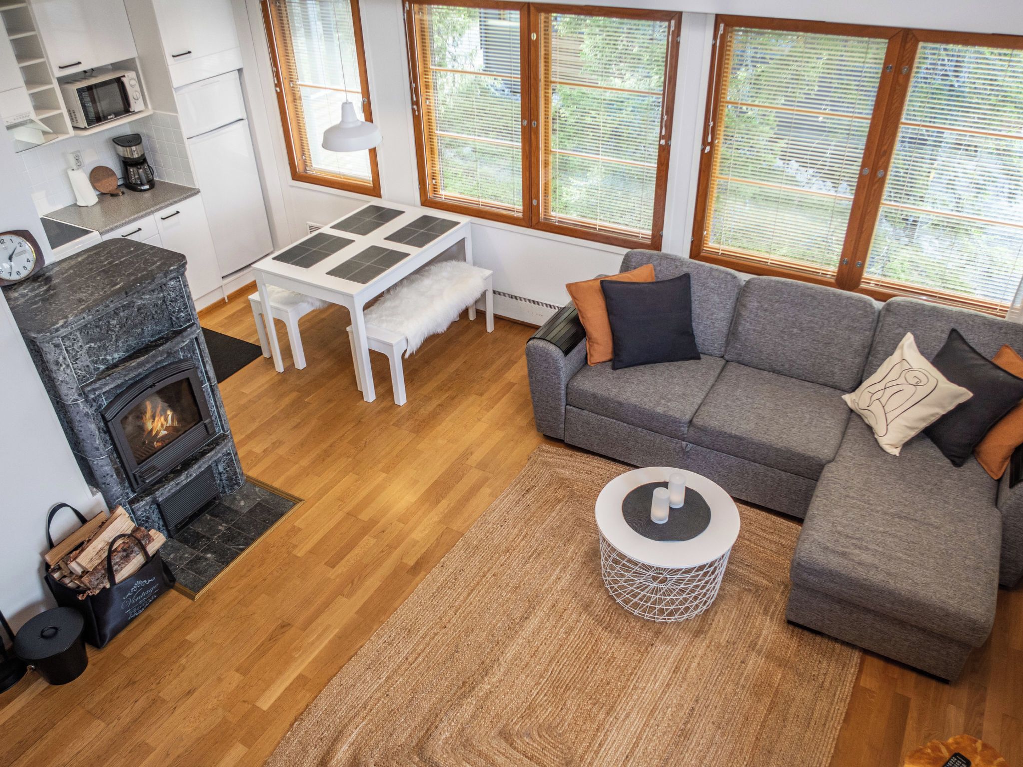 A modern living room with a fireplace, a sofa, a coffee table, and a dining area with a table and chairs.