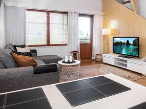Un salon moderne avec un canapé, une table basse et un téléviseur.