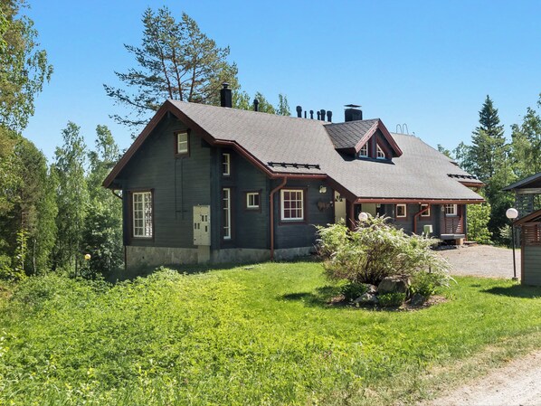 A two-story house with a sloped roof, a chimney, and a small porch.