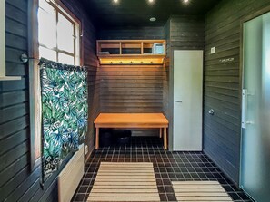 A compact room with a bench, a door, and a window with a curtain.
