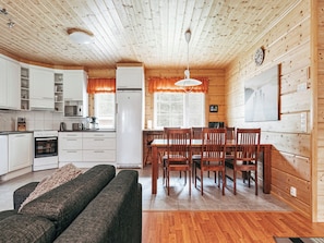 A cozy cabin-style interior with a dining area, kitchen, and living space. - Aapeli iso by Interhome (Ähtäri)