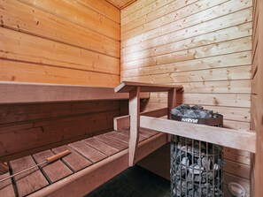 A sauna room with wooden benches and a stone fire pit labeled 'HARVIA'. - Aapeli iso by Interhome (Ähtäri)
