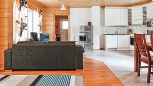 A cozy cabin interior with a living area, kitchen, and dining space. - Aapeli iso by Interhome (Ähtäri)