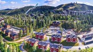 Zona residencial con varios edificios de apartamentos, calles y un telesilla al fondo.