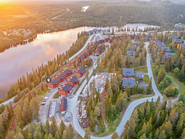 Vista aérea de un resort con varias edificaciones, caminos y un lago.