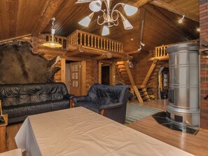 A cozy cabin interior with a fireplace, leather seating, and a wooden ceiling. - Harrila by Interhome (Mikkeli)
