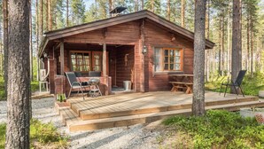 A rustic cabin with a porch, seating area, and a small deck. - Kanerva by Interhome (Sotkamo)