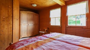 Una camera in legno con un letto, una sedia e un armadio.