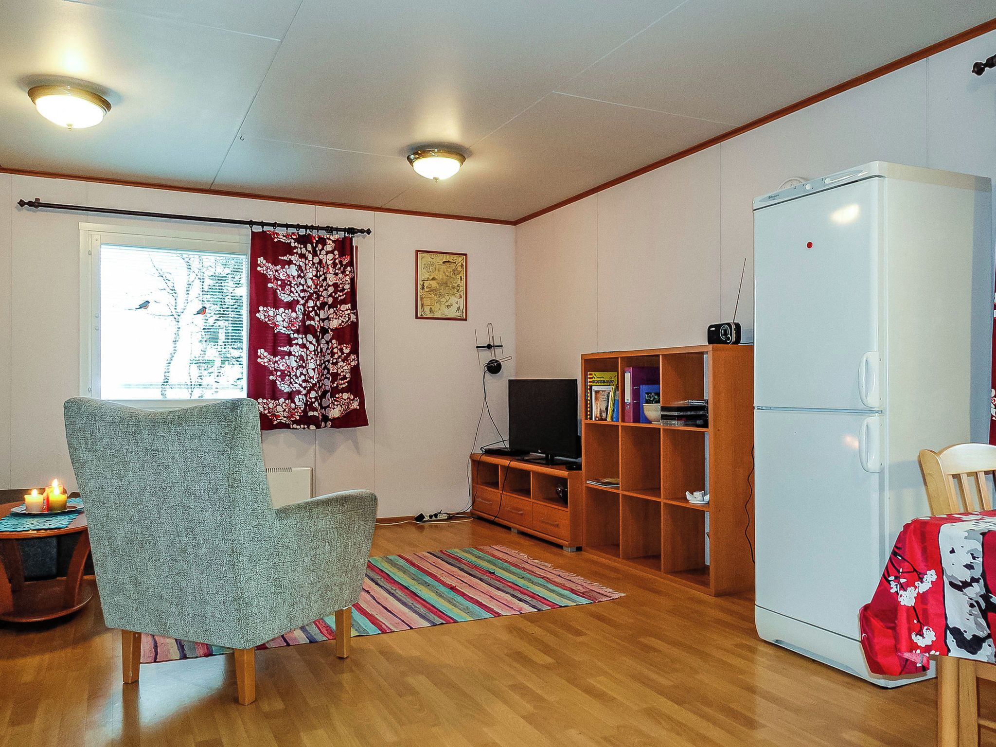 Un salon équipé d’un téléviseur, d’une bibliothèque et d’un réfrigérateur.