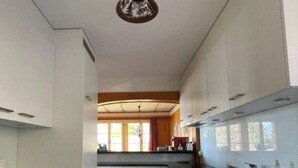 A kitchen with white cabinets, a black countertop, and a patterned floor.