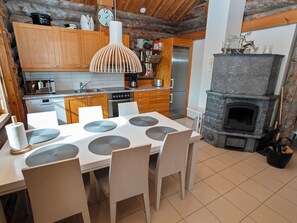 Une cuisine moderne avec des meubles en bois, une cheminée en pierre et une table à manger agrémentée de sets de table.