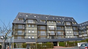 Un edificio de varios pisos con una fachada simétrica, que presenta balcones en cada nivel.