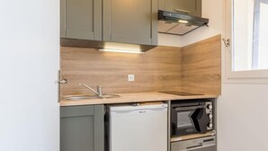 Una cocina compacta con lavavajillas integrado, horno y una pequeña encimera.