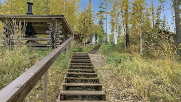 Puinen portaikko, joka johtaa mökkiin metsäisellä alueella.